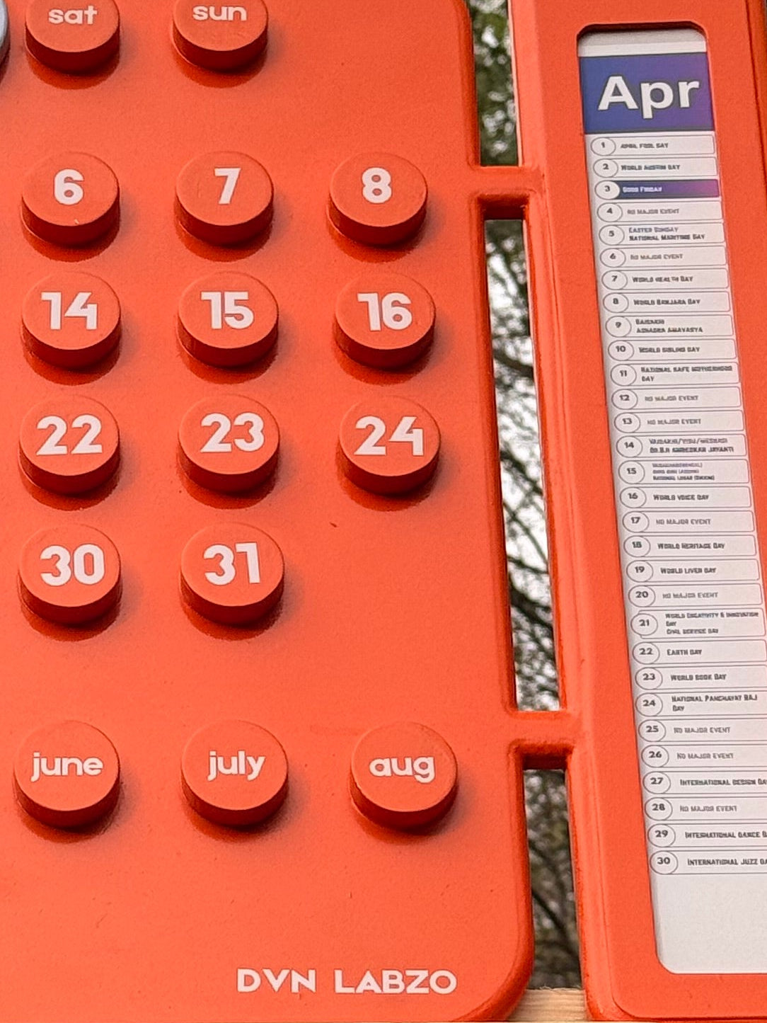 Orange inflatable mat with circular patterns on a wooden stand outdoors.